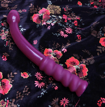 Load image into Gallery viewer, Tantus g force silicone wand dildo lying on flowery bedsheet with the matte ribbed handle and glossy dildo tip and unrealistic penis head shape Tantus flurry dual density silicone dildo in pink standing upright with realistic underneath of the penis head on display - Sex Siopa, Ireland&#39;s Best Adult Shop for Sex Toys, Lubricants, and Accessories
