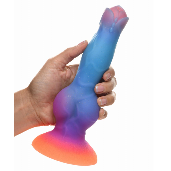 A rear view of a hand holding the vertical silicon textured alien dildo in orange/purple/blue colour scheme.