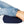 Lower torso and legs of a person wearing denim jeans, lying on a navy blue Dame Pillo Positioning Wedge