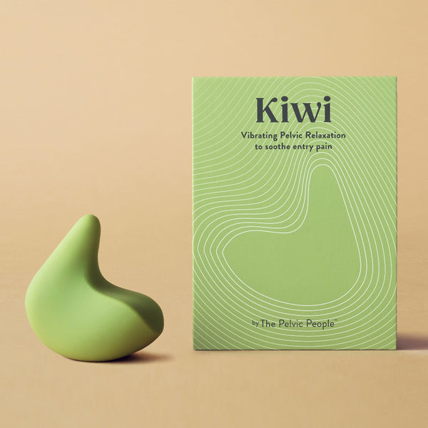 Kiwi therapeutic pelvic health vibrator next to its green box in front of a peach coloured background
