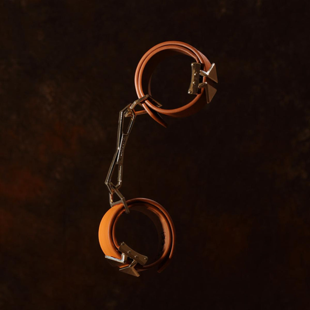 LOCKINK Leather Cuffs laid out on a wooden style brown background