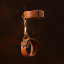 Load image into Gallery viewer, LOCKINK Leather Cuffs on a wooden style brown background with the two cuffs at right angles to one another
