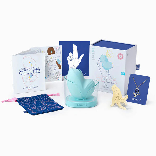 Biird Namii Rechargeable Dual "Sucker" & Vibrator in light blue. Shown in its light blue hued holder with its features pointed out. Alongside additional Biird themed packaging, cards, and jewellery.