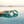 Lifestyle photo of a woman's hand holding out the Biird silicone handcuffs over a calm pool of water.
