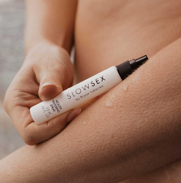 Slow Sex Mouthwatering Spray laid on a naked arm with drops of liquid next to it