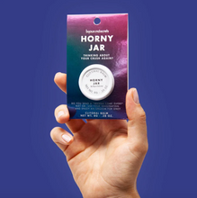 Load image into Gallery viewer, Hand holding up package of Bijou Indiscreets Horny Jar Clitoral Balm