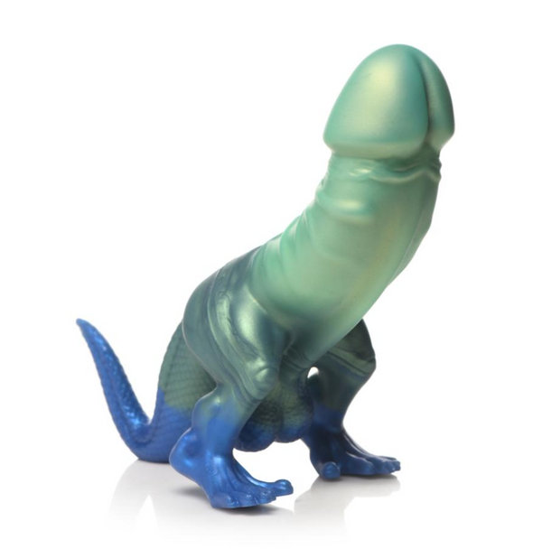 A novelty realistic dildo with dinosaur legs and tail, featuring a smooth gradient from light mint green at the top to deep metallic blue at the base, standing on a reflective white surface.