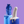 A single Biird Boo & Bae Silicone Suction Cup Dildo in grainy white and blue. Shown Stood on a dripping blue pillar on a lilac background. Alongside a Biird bag and fingering keychain on a light blue dripping pillar.