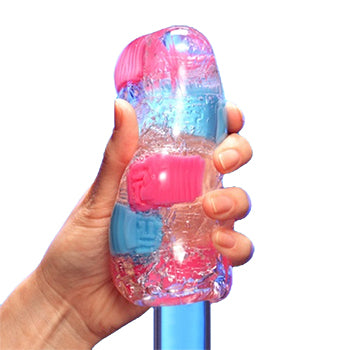 Hand masturbating a Multicoloured Tenga Bobble Masturbation Sleeve over a glass looking dildo.