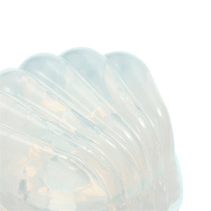 Close up of the Tengalroha Petite Clit Stimulator shiny iridescent pearl-like shell shape on white background