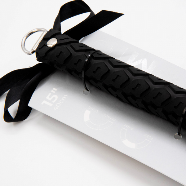 Close up of the tyre tread spanking paddle handle with a metal loop to hang up the paddle and affixed bow in its packaging - Sex Siopa stocks Ireland's best sex toys, lubricants and accessories. 