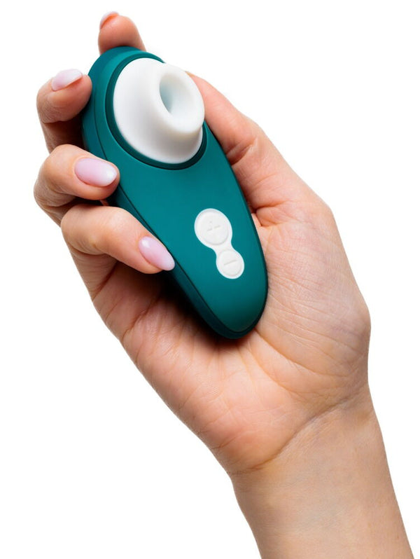 Hand holding a Womanizer Liberty 2 Rechargeable "Sucking" Vibrator in shades of green and white.