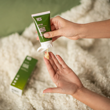 Load image into Gallery viewer, A woman&#39;s hands squeezing a small bottle of Yes OB plant oil based personal lubricant onto the pads of her fingers.