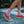 Biird branded Clit Socks in a pink and light pink colour scheme being worn on bare legs in red shoes in a walking outdoor scenario