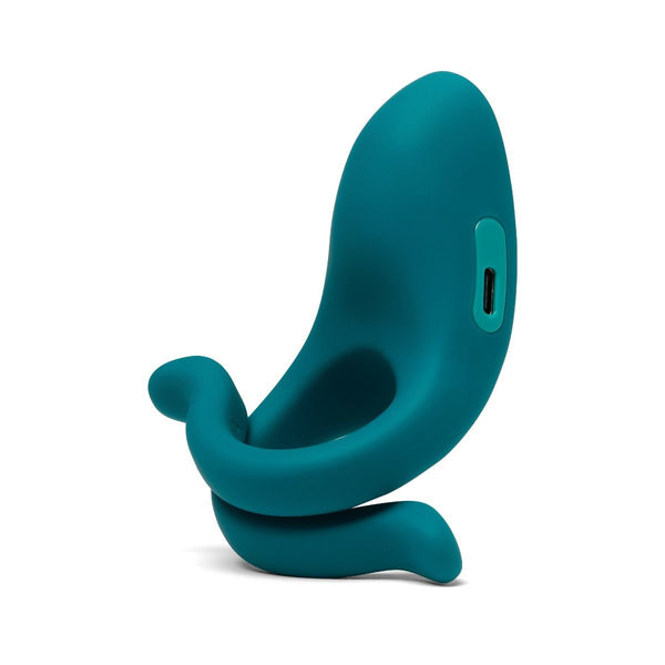 a three quarters view of the teal Dame Hug vibrating cock ring with a usb-c port. It is on a white backgroun.