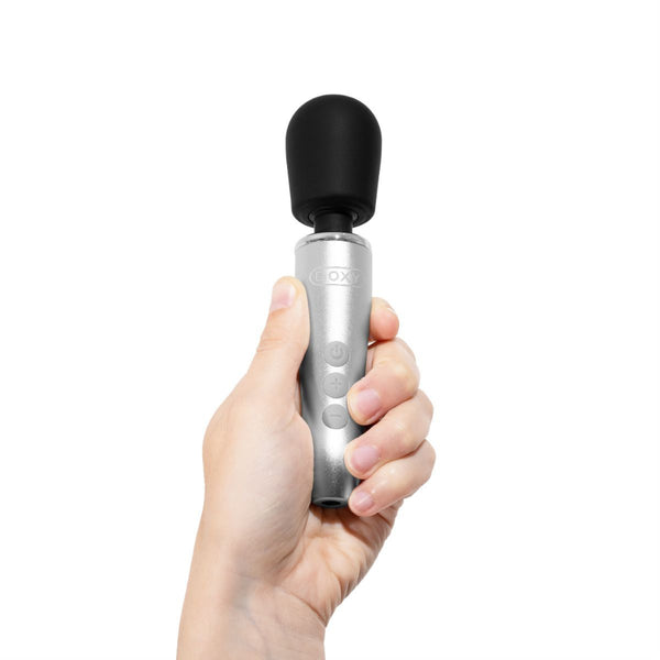 A white hand holding a Doxy Go rechargeable mini wand vibrator.