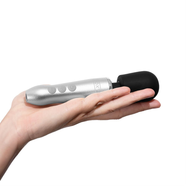 Hand holding a Doxy Go rechargeable wand vibrator in front of a white background