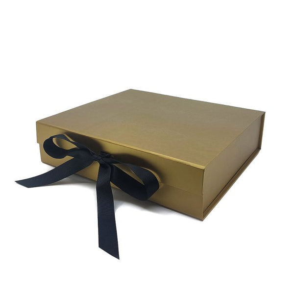 One gold luxury gift box with a black bow, on a white background