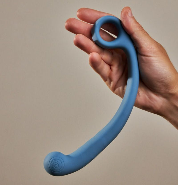 a hand holds the Svibe Snail Axi in front of a beige background.