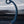 The Svibe Axi vibrator stands on one end dripping with lubricant in front of a blurry background of a lake. 