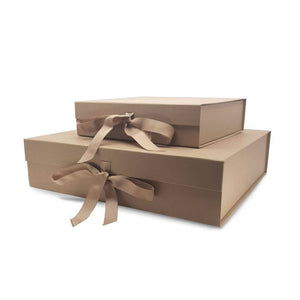 Two luxury foldable gift boxes in gold/brown with bows. One small, one larger, laid on top of each other on a white background