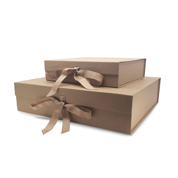 Two luxury foldable gift boxes in gold/brown with bows. One small, one larger, laid on top of each other on a white background