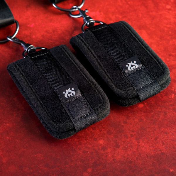 SEI MIO - Doorway Control Play - Adjustable Over Door Cuff Restraints. Close up of the cuffs on a red crushed velvet background.