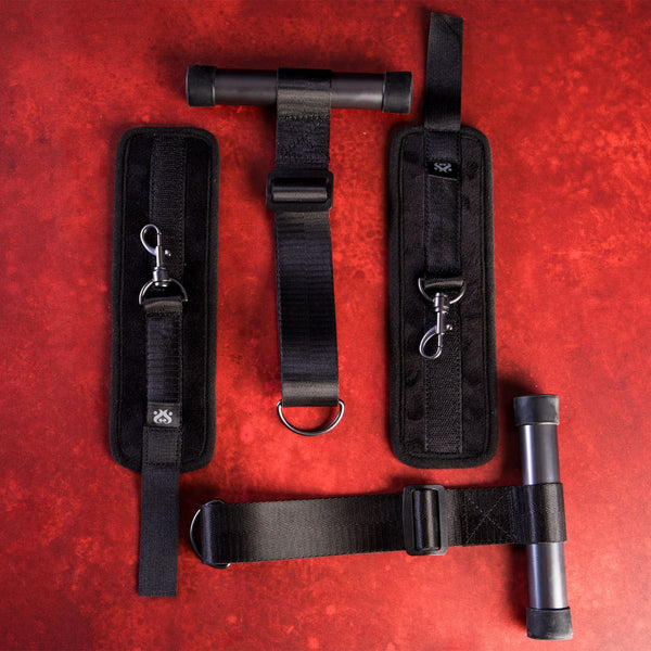 Components of the SEI MIO - Doorway Control Play - Adjustable Over Door Cuff Restraints laid out on a red crushed velvet background.
