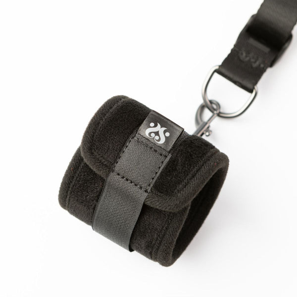 Close up of the wrist restraint in black, part of the Sei Mio Bed-Spreader Under Bed Restraint System on a white background.