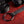Close up of the strap and buckle components. Part of the Sei Mio Bed-Spreader Under Bed Restraint System in black, on a red background.