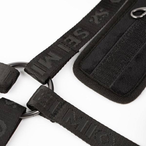 Close up on the buckle of the Sei Mio Bed-Spreader Under Bed Restraint System in black, laid out on a white background.