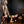 Lifestyle photo of a tattooed topless male simulating doggy style sex with a tattooed female in lingerie using the SEI MIO - Behind Closed Doors - Adjustable Door Hanging Sex Swing. Background of flooring, furniture and walls.