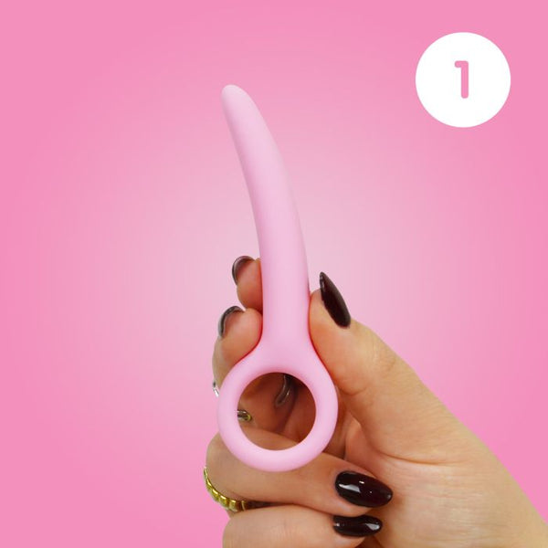 Woman's hand holding size 1 of the Skins Care silicone dilator set against a pink background.