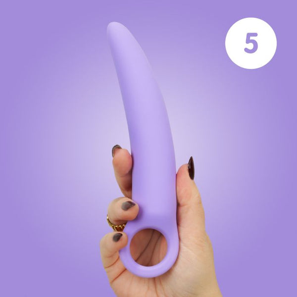 Woman's hand holding size 5 of the Skins Care silicone dilator set against a lilac background.