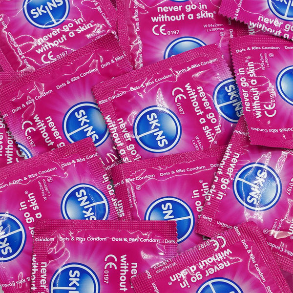 Multiple packs of Skins condoms with pink and blue packaging.
