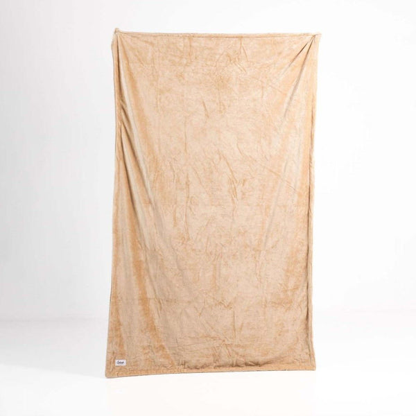 Image shows a cream coloured faux fur waterproof splash blanket fully unfolded to demonstrate its shape and size