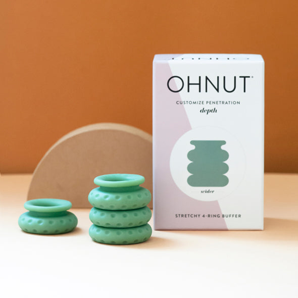 Picture of the Ohnut intimacy bumpers in light green shown alongside its packaging on a white table with an orange background. Sex Toys Ireland - Sex Siopa - Ohnut is the world's first intimacy bumpers to customise penetration and allow for more comfortable, pain free sex. Oh is ideal for folks suffering from vaginismus, endometriosis, or recovering from gynae surgery. 