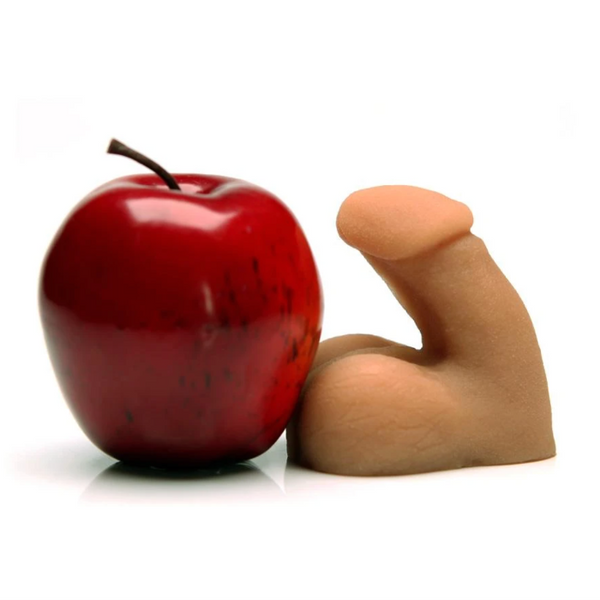 Tantus On the Go silicone packer for gender expression alongside an apple. - Sex Siopa, Ireland's best sex toy shop