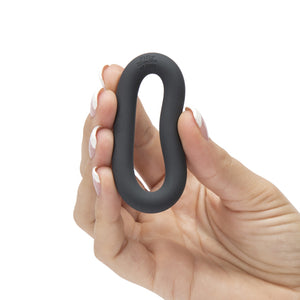 Hand compressing the 50 Shades of Grey Perfect O Cock Ring in Black into an oval shape on white background